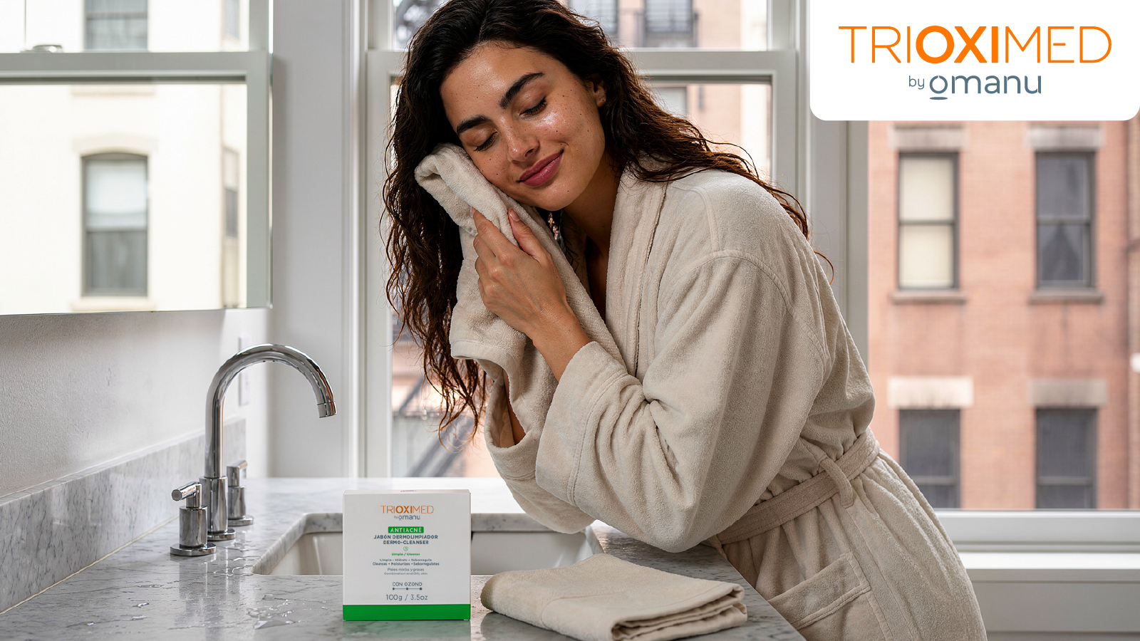 Mujer secando su rostro después de la limpieza facial junto al Jabón Dermolimpiador Antiacné Trioximed con aceite ozonizado para piel grasa.